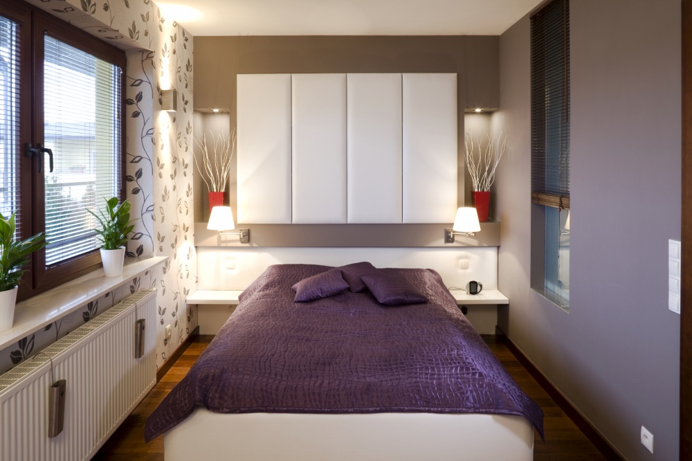 Hình ảnh phòng ngủ nhỏ nổi bật với bộ ga gối màu tím, giấy dán tường họa tiết lá cây tinh tế
