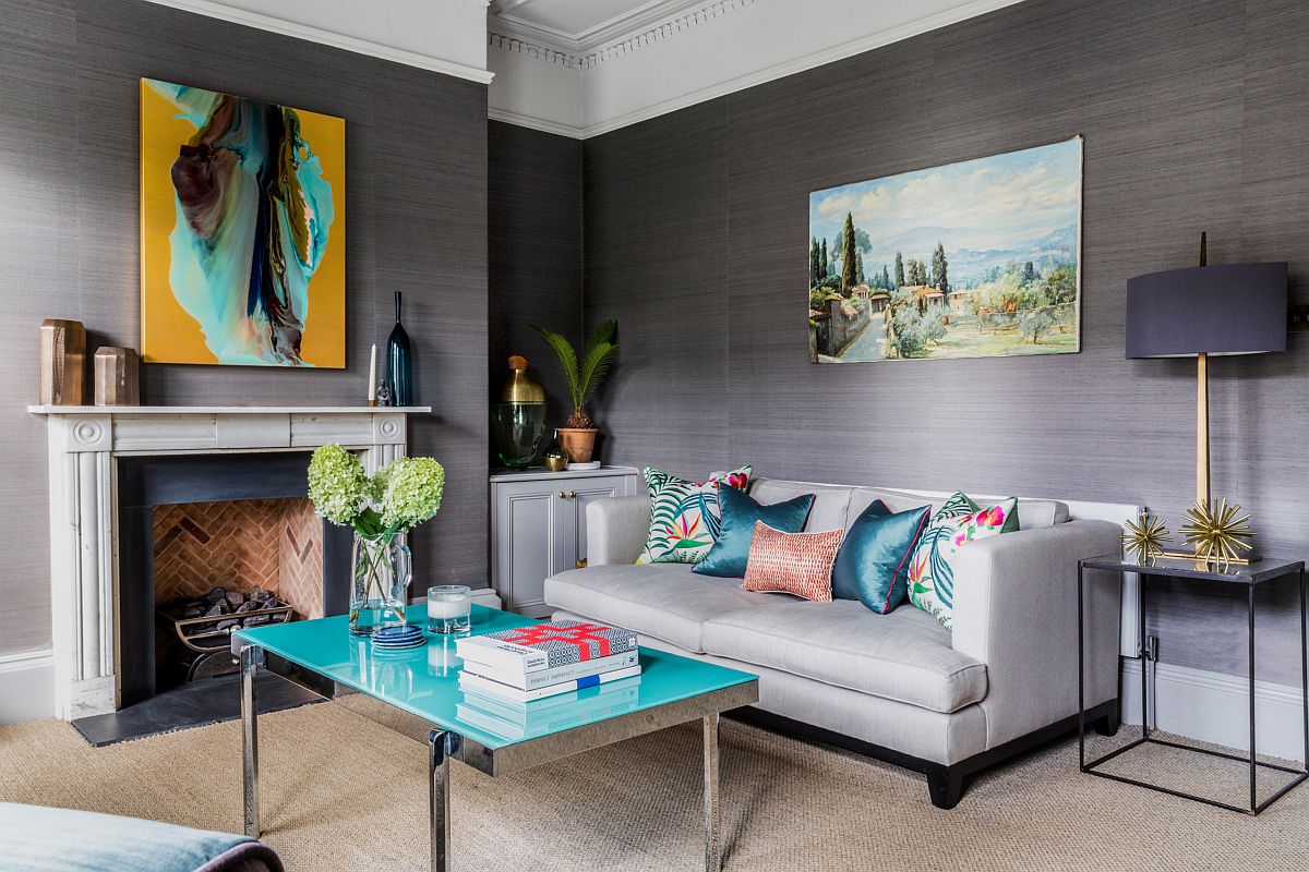 Hình ảnh minh họa cho việc trang trí phòng khách mùa hè với sofa xám, gối tựa xanh lam, tranh treo tường trừu tượng