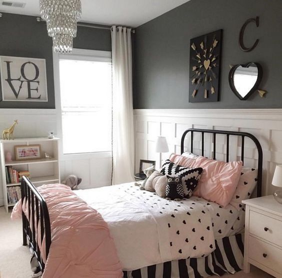 Hình ảnh phòng ngủ bé gái với giường sắt chăn gối màu hồng, ga họa tiết trái tim màu đen
