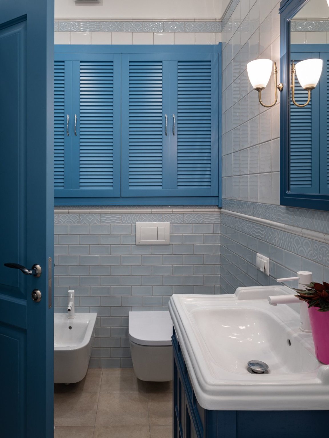 hình ảnh phòng tắm nhỏ mang hơi hướng cổ điển với cửa vào, cửa sổ, tủ đồ màu xanh