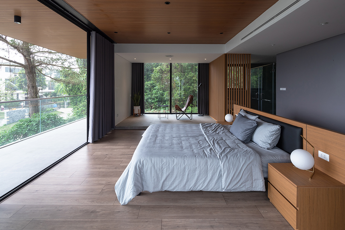 hình ảnh phòng ngủ biệt thự rộng thoáng với trần gỗ, giường nệm êm ái, cửa kính lớn