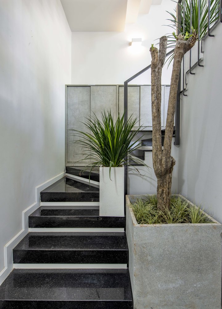 hình ảnh cận cảnh cầu thang nhỏ kết nối các tầng lầu văn phòng với các bậc ốp đá màu đen bóng