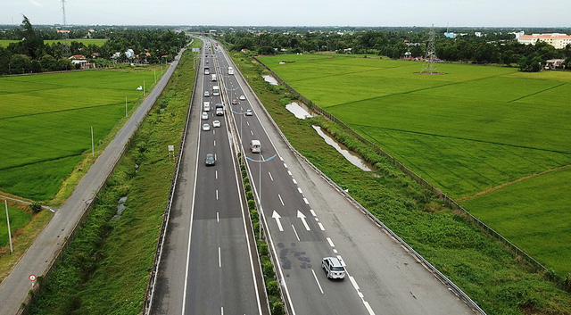 hình ảnh cao tốc có nhiều ô tô đang chạy, hai bên là ruộng lúa, nhà dân, cây cối
