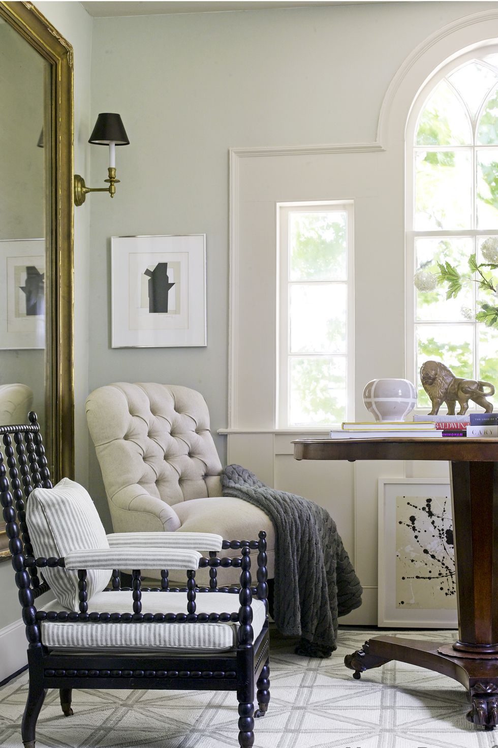 hình ảnh góc thư giãn bên cửa sổ kính lớn với ghế bành, sơn tường màu xanh xám, chăn màu rêu
