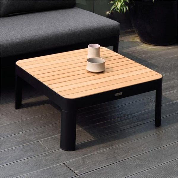 hình ảnh cận cảnh mẫu bàn cà phê có bề mặt làm từ gỗ tếch tự nhiên, cạnh đó là ghế sofa màu xám