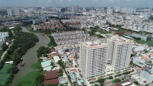 hình ảnh một góc TP.HCM nhìn từ trên cao với các tòa nhà cao tầng xen kẽ khu dân cư thấp tầng, cây xanh, sông hồ