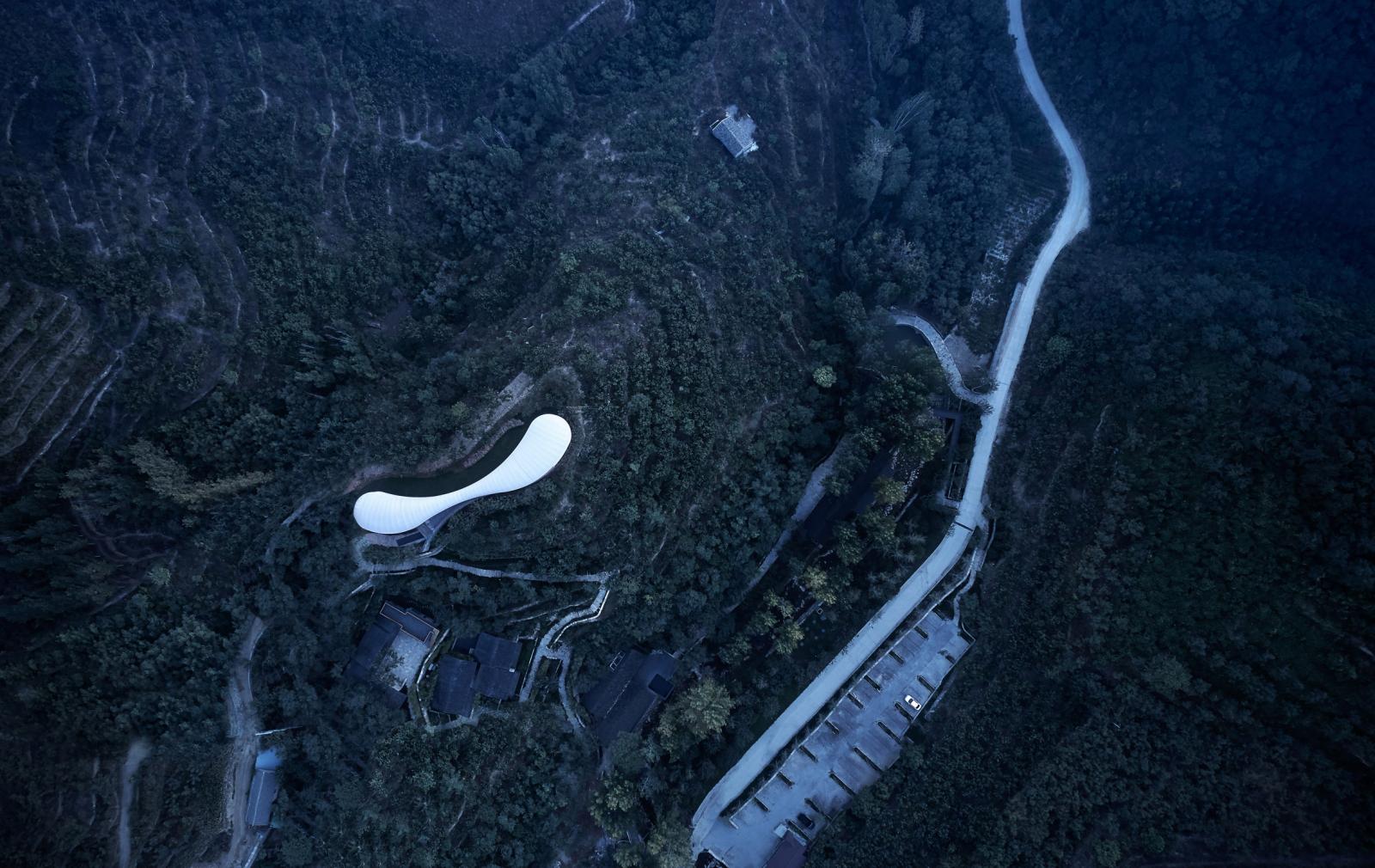 hình ảnh toàn cảnh công trình độc đáo nằm trên sườn núi đá ở Trung Quốc với tông màu trắng tinh khổi, bao xunh quanh là cây cối