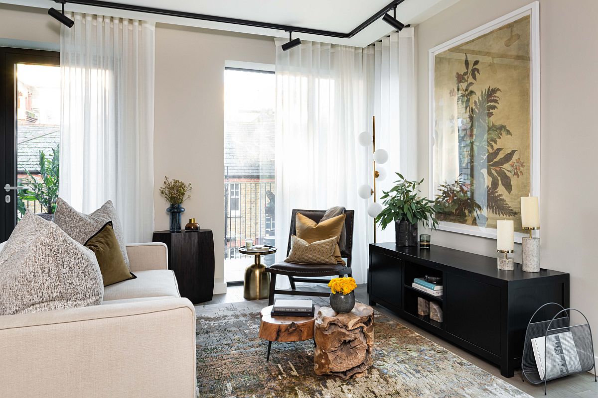hình ảnh phòng khách căn hộ tông màu trắng - be chủ đạo với sofa trắng, bàn trà gỗ nguyên cây, tủ kệ màu đen, cây xanh trang trí