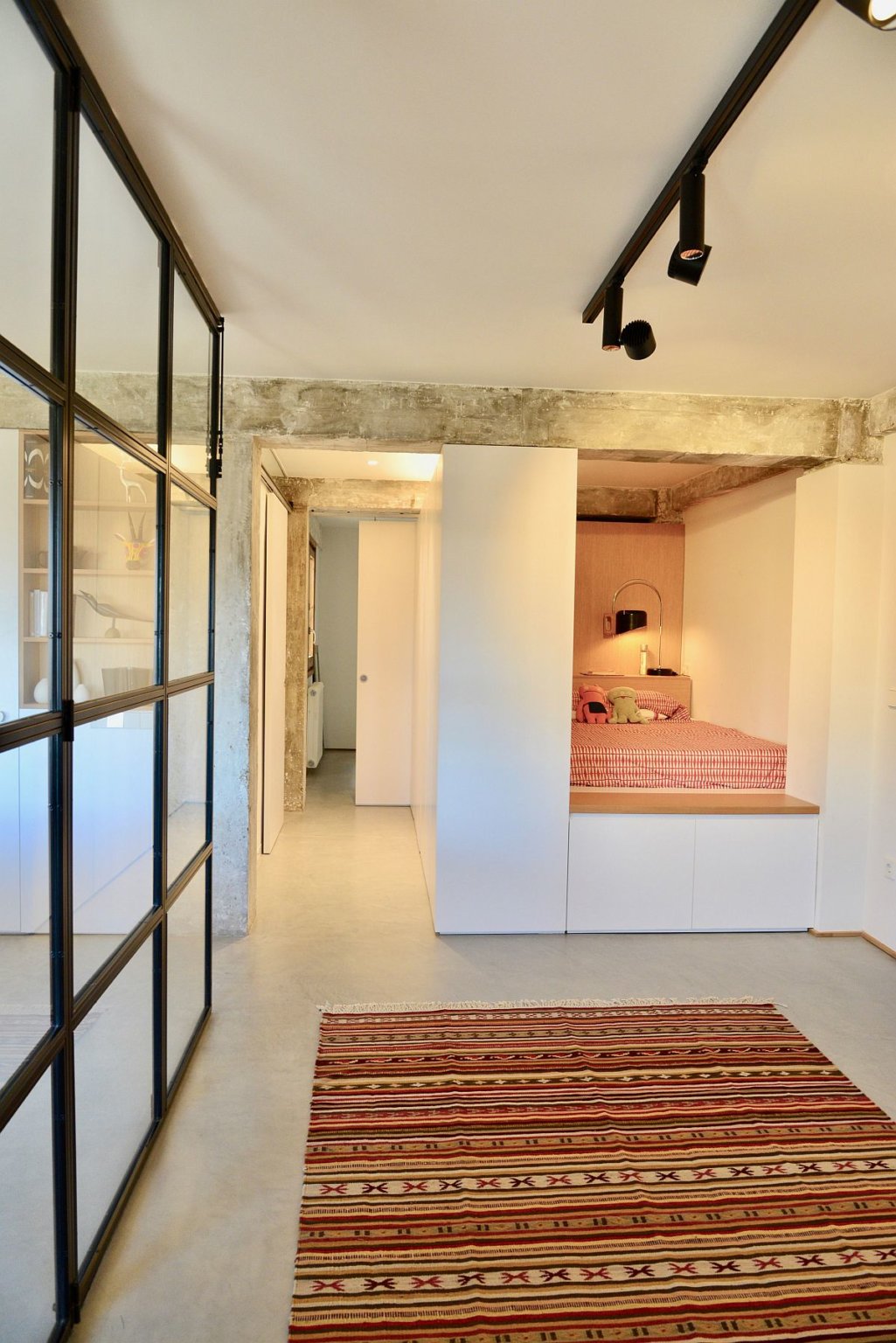 hình ảnh phòng ngủ nhỏ ấm cúng trong hốc tường với ga gối, chăn màu cam đất