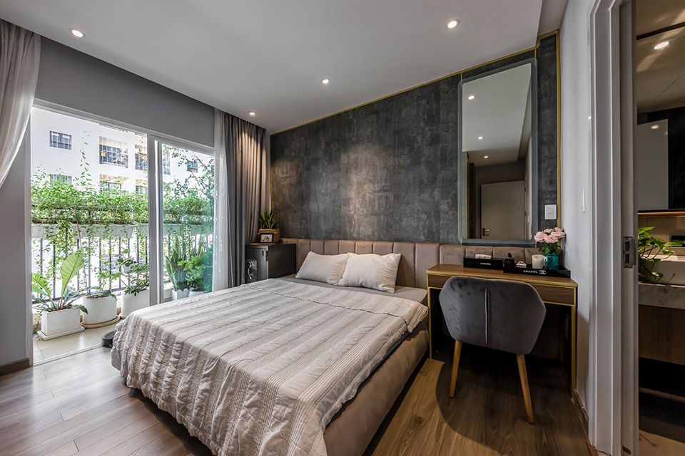 hình ảnh phòng ngủ tiện nghi trong căn hộ 105m2, có cửa kính mở ra ban công trồng cây xanh