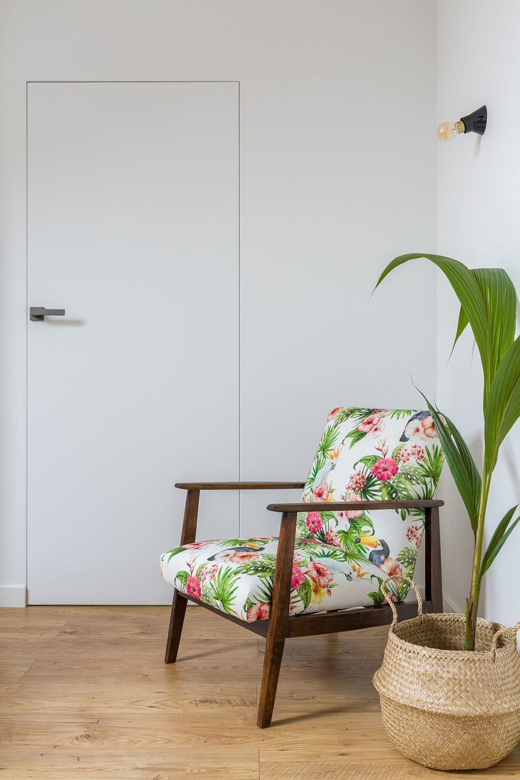 hình ảnh góc đọc sách thoáng sáng, đẹp mắt trong căn hộ 52m2 với ghế tựa bọc nệm họa tiết hoa lá nhiệt đới, chậu cây xanh trang trí