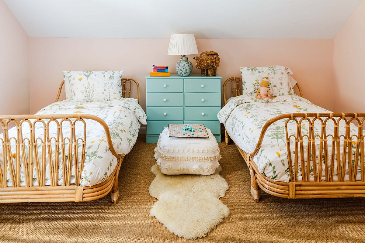 hình ảnh phòng ngủ chung của hai con gái tông màu pastel nhẹ nhàng với giường mây tre đan, tủ ngăn kéo ở giữa màu xanh ngọc, ga gối họa tiết hoa lá