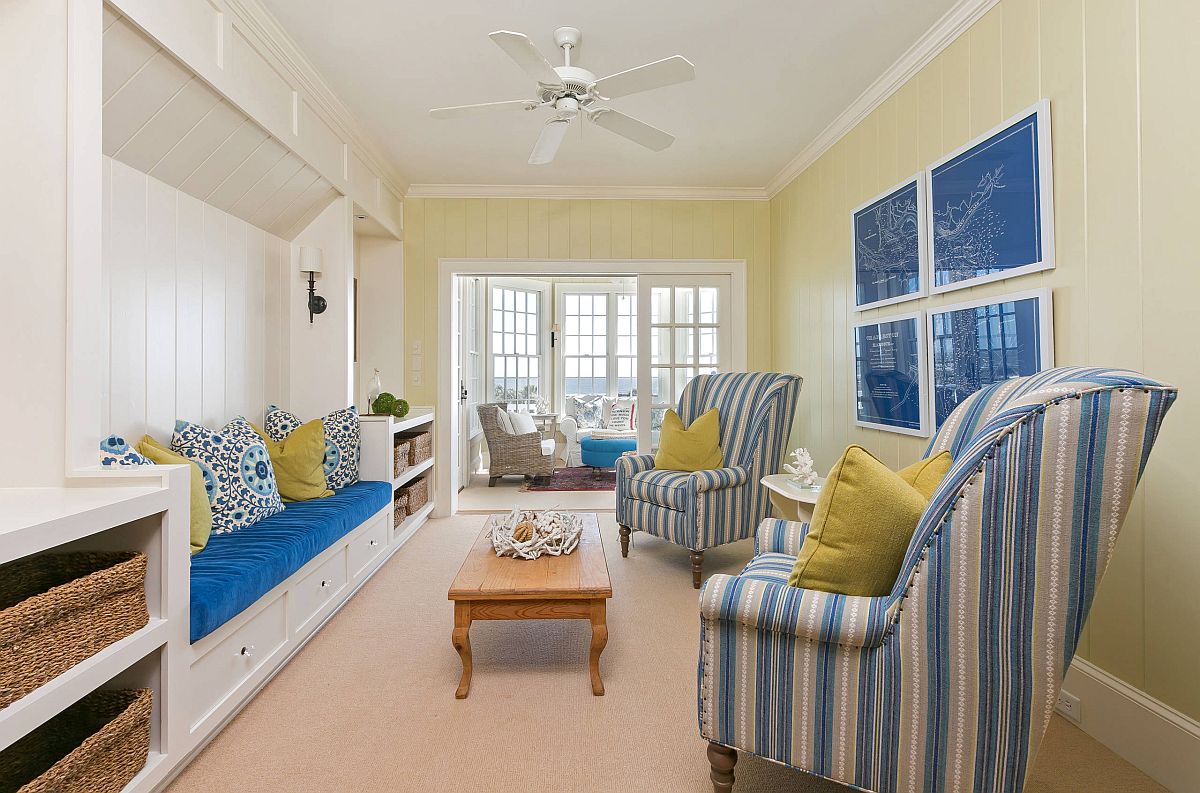 hình ảnh phòng khách phong cách bãi biển với sofa, ghế bành màu xanh dương - trắng, gối tựa màu vàng tạo điểm nhấn