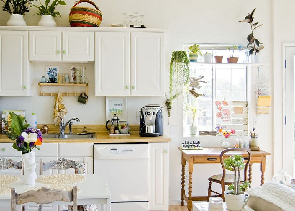 hình ảnh toàn cảnh phòng bếp mùa hè màu trắng với điểm nhấn là những chậu cây xanh tươi