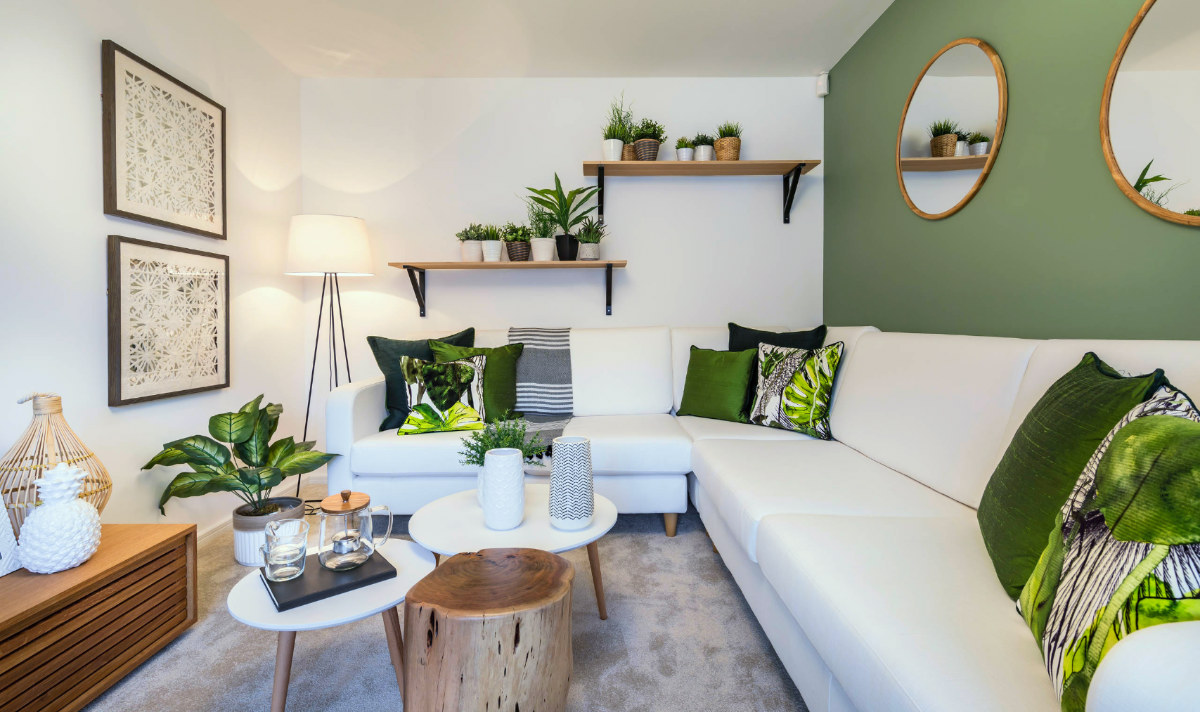 hình ảnh phòng khách được trang trí với tường, gối tựa màu xanh lá, cây xanh tạo điểm nhấn