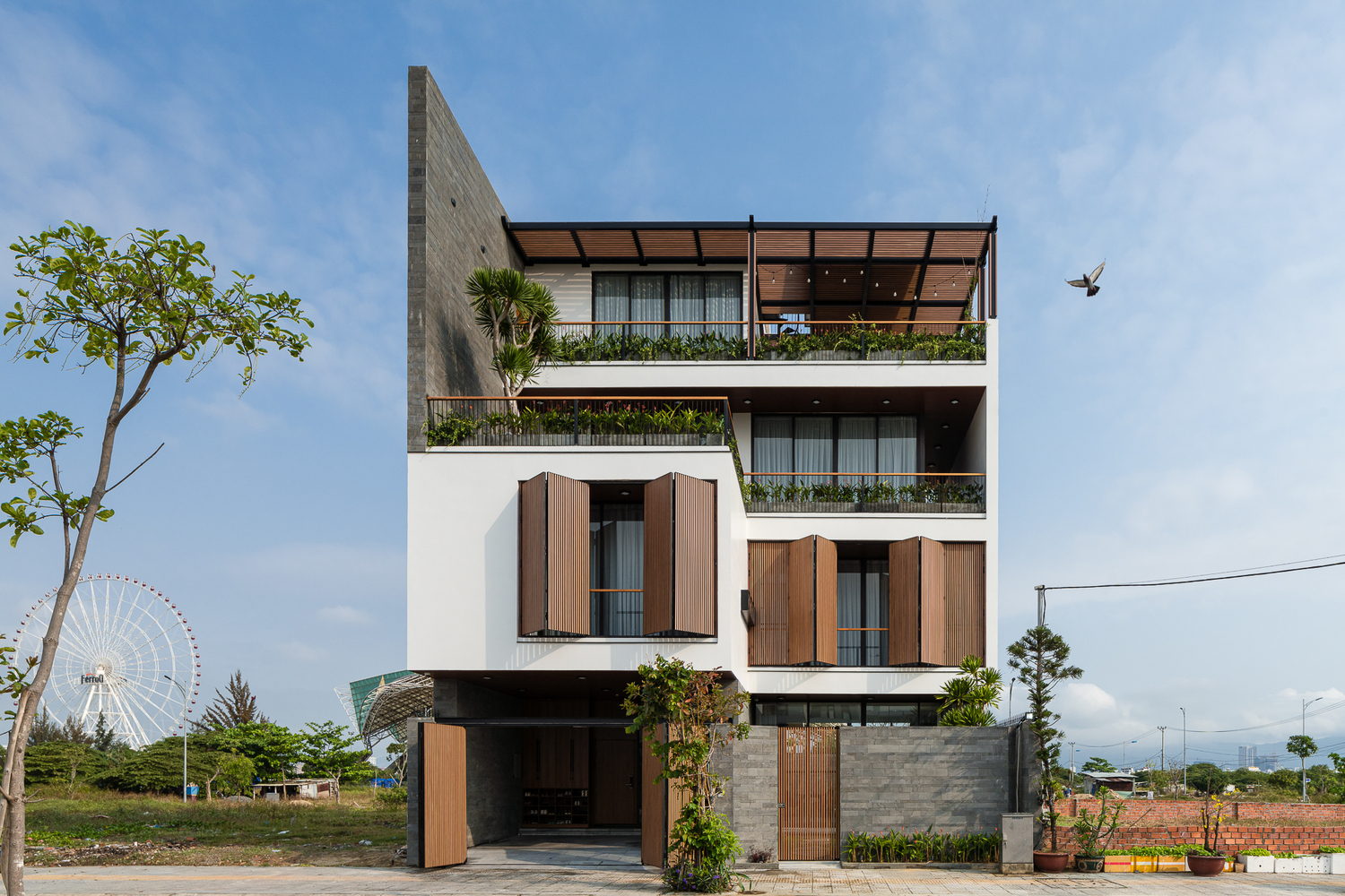 hình ảnh toàn cảnh biệt thự 4 tầng ở Đà Nẵng với tông màu trắng và gỗ nâu kết hợp hài hòa