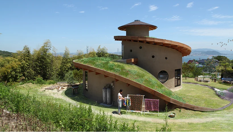 hình ảnh toàn cảnh ngôi nhà hình xoắn ốc trên đảo Awaji, Nhật Bản với mái phủ cỏ xanh mướt