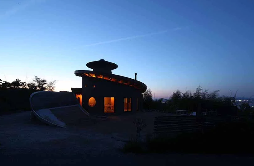 hình ảnh khung cảnh ngôi nhà xoắn ốc về đêm với ánh đèn vàng ấm áp