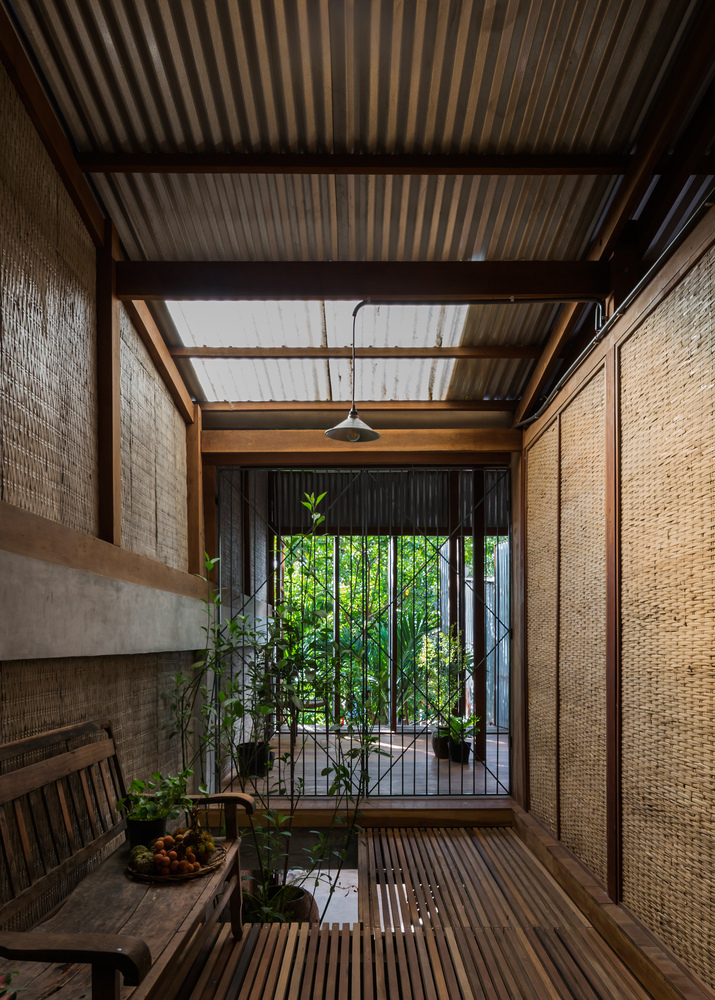 hình ảnh góc thư giãn bình yên trong nhà 3 tầng với ghễ gỗ cũ, sàn gỗ, cây xanh
