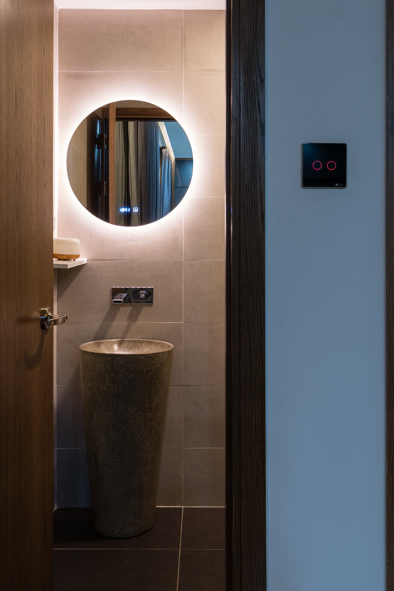 hình ảnh góc phòng tắm với bồn rửa lạ mắt, gương tròn tích hợp đèn LED ánh sáng trắng