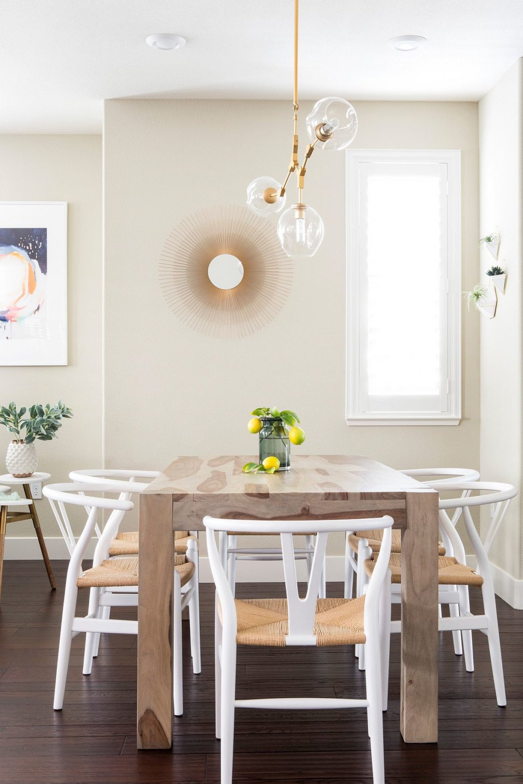hình ảnh phòng ăn nhỏ phong cách bãi biển với bàn gỗ hình chữ nhật, ghế ngồi màu trắng, cây xanh tạo điểm nhấn