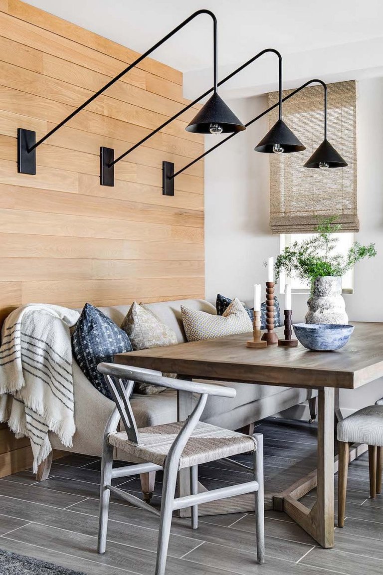 hình ảnh phòng ăn với bàn gỗ, ghế sofa xám, đèn treo tường màu đen độc đáo