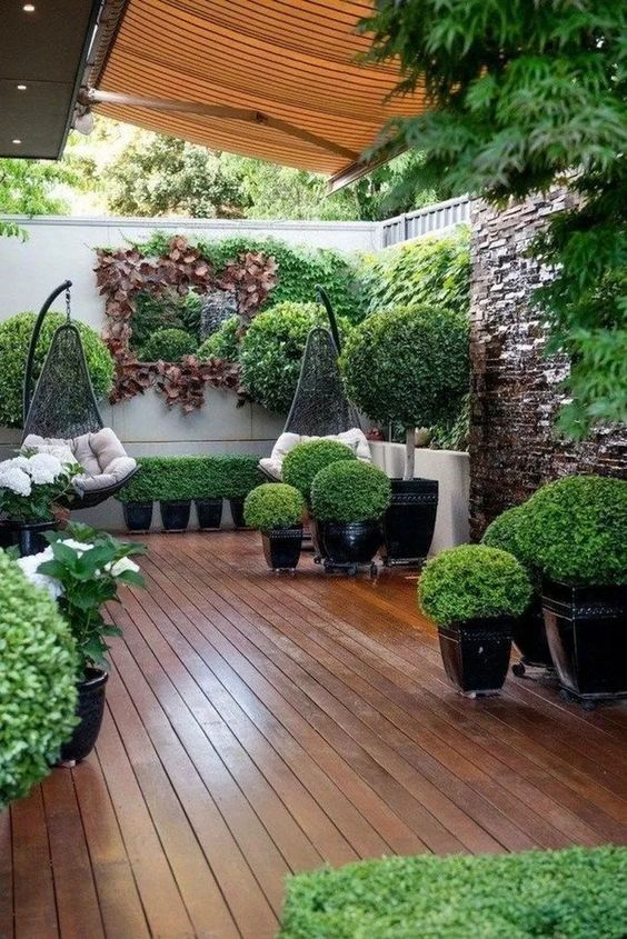 Khu vườn nhỏ hiện đại với rất nhiều cây xanh trồng trong chậu, được cắt tỉa tỉ mẩn. Bộ đôi ghế treo mang đến phút giây thư giãn thoải mái nhất.