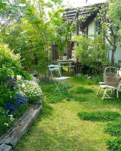 Góc sân vườn phong cách cổ điển với thảm cỏ xanh, cây lớn, nội thất mang hơi hướng hoài cổ.