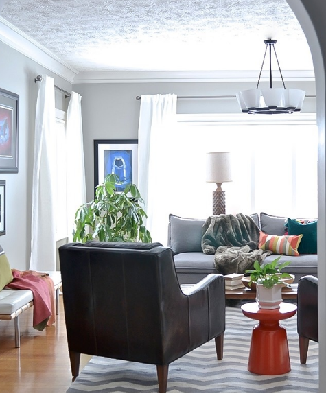 hình ảnh phòng khách phong cách hiện đại với sofa ghi xám, ghế bành màu đen, thảm trải kẻ sọc, rèm cửa sổ màu trắng