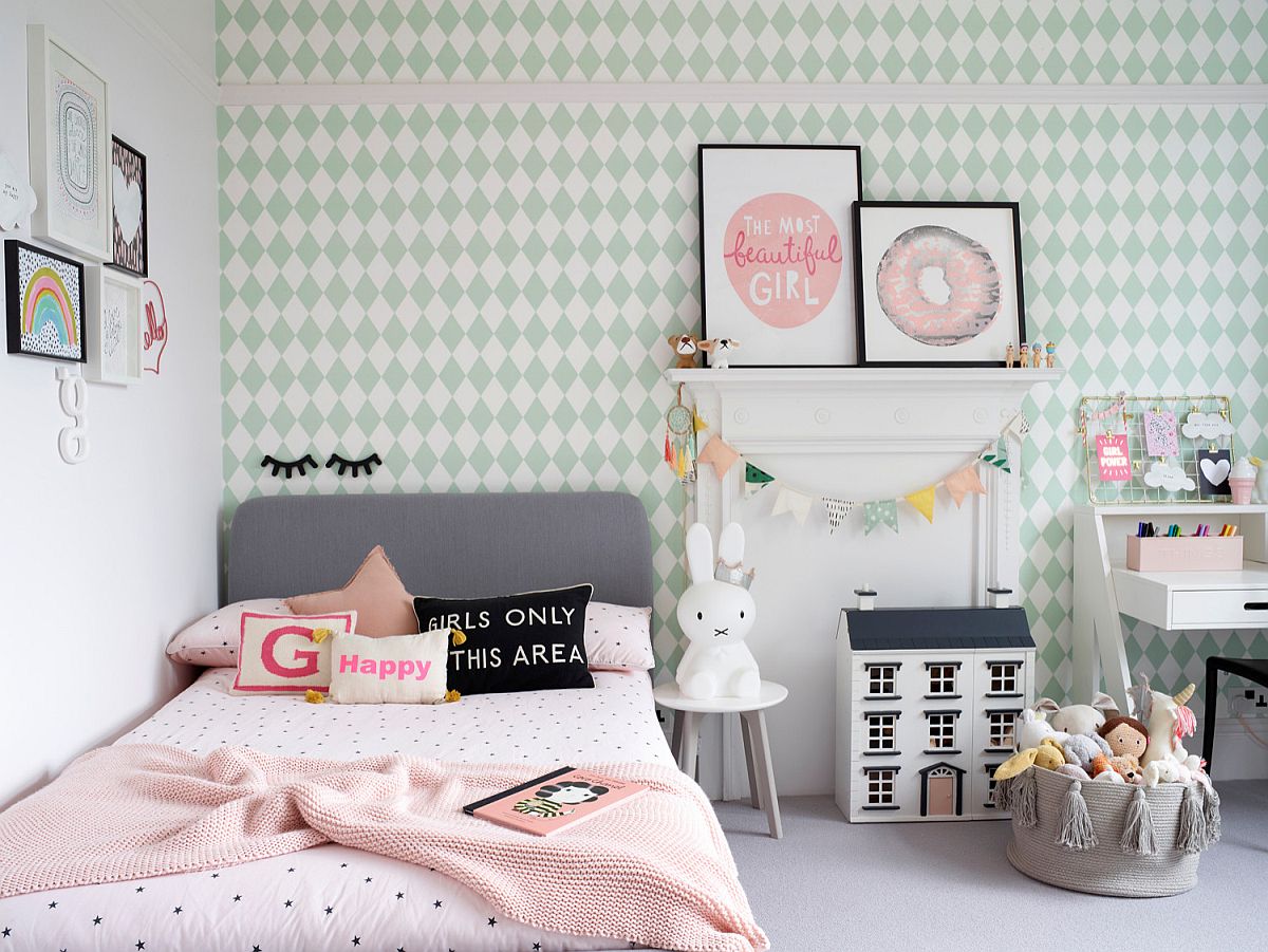 hình ảnh phòng ngủ con gái với giường đơn nhỏ gọn, ga gối màu hồng, tường dán giấy họa tiết hình học màu xanh ngọc