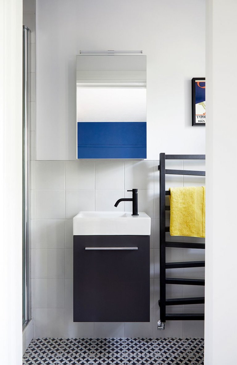 phòng tắm căn hộ 2 phòng ngủ với gạch lát đen trắng, bồn rửa đen trắng, thang lưu trữ màu đen