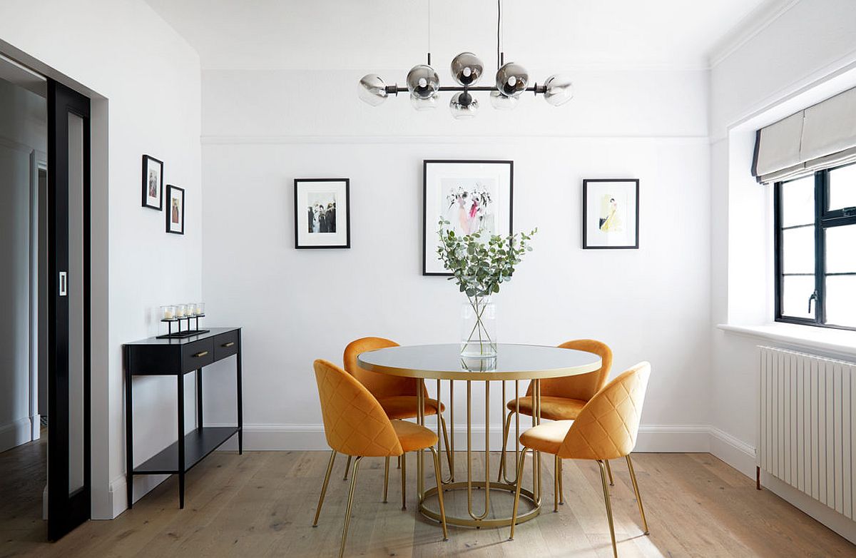 hình ảnh phòng ăn với bàn tròn màu trắng, ghế màu vàng, tranh treo tường, cửa sổ kính