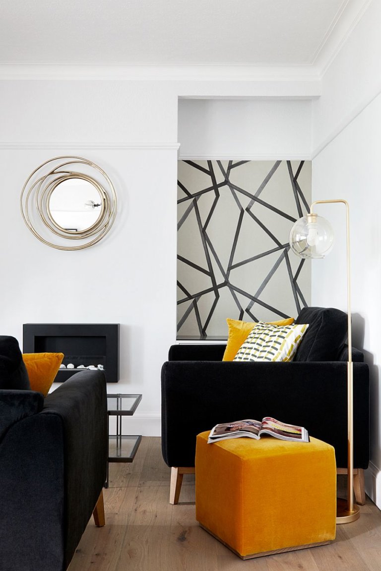hình ảnh một góc phòng khách với sofa da màu đen, gối tựa, bàn phụ màu vàng