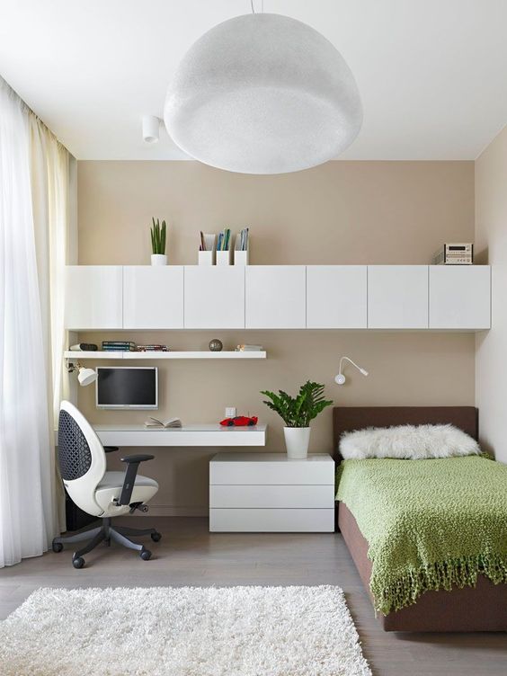 hình ảnh phòng ngủ cho con trai với giường đơn, chăn xanh lá, tủ kệ màu trắng gắn tường, bàn học