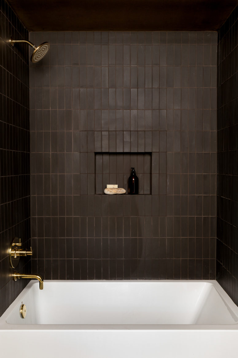 hình ảnh phòng tắm màu nâu trầm chủ đạo với vòi sen, vòi rửa bằng đồng sáng bóng