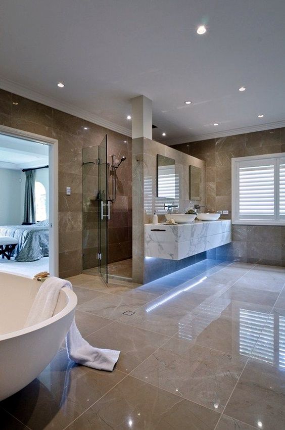 hình ảnh phòng tắm lớn hiện đại với gạch ốp lát màu nâu nhạt, đèn LED âm trần, bàn trang điểm lát đá cảm thạch
