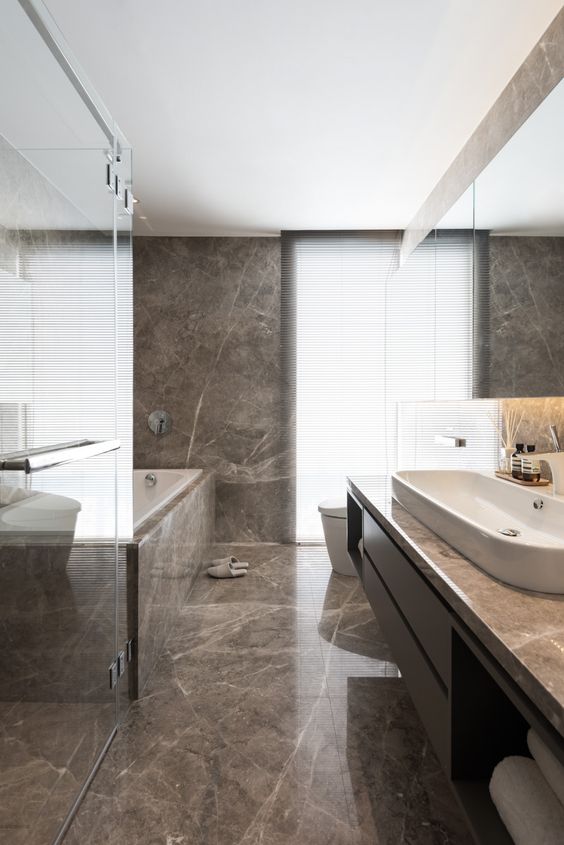 hình ảnh phòng tắm tối giản với đá cẩm thạch màu nâu, bồn tắm ốp đá cẩm thạch sang trọng và khung cửa cao rộng mang đến ánh sáng tự nhiên ngập tràn.