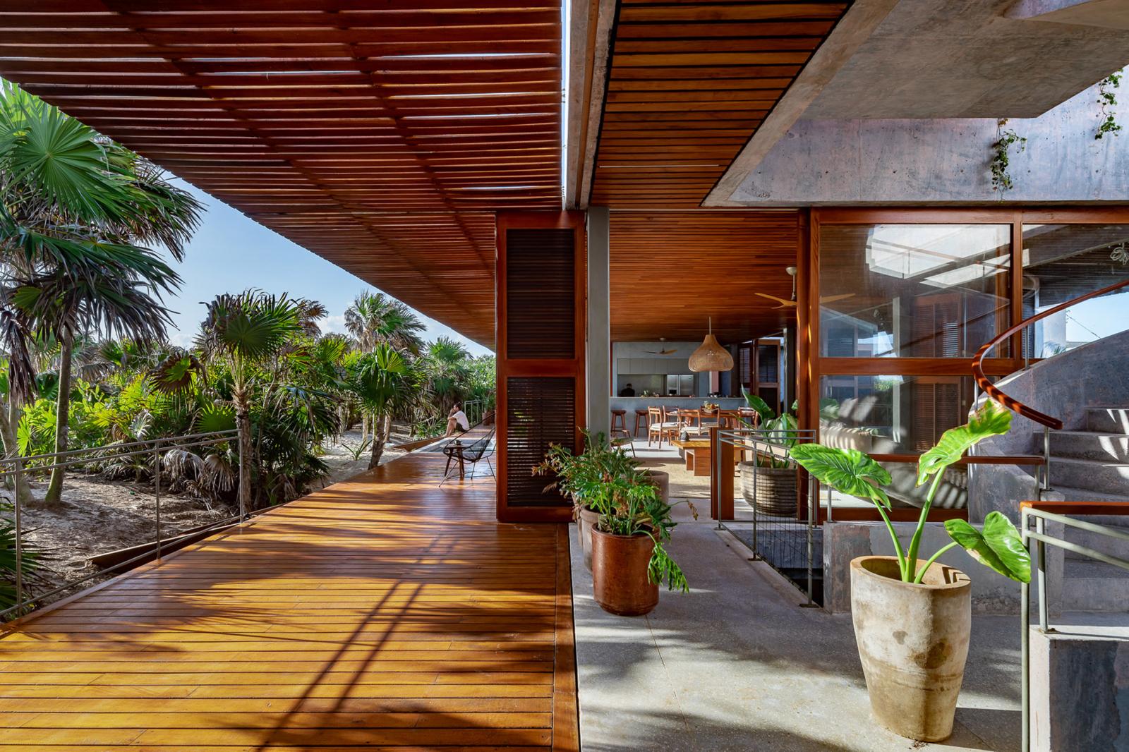 hình ảnh hiên nhà bê tông với lam gỗ che chắn nhìn ra vườn cây xanh tốt