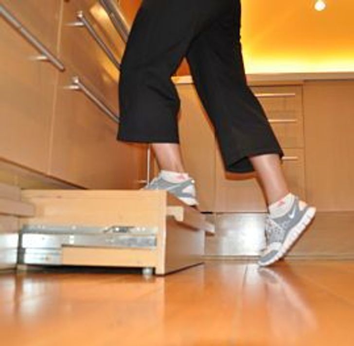 hình ảnh cận cảnh một người đang đặt chân lên ngăn kéo tủ bếp tích hợp bậc thang