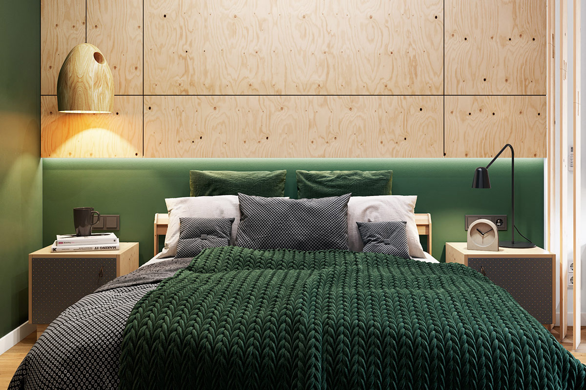 hình ảnh phòng ngủ với tường đầu giường ốp gỗ, đèn thả cùng tông, ga gối màu xanh lá