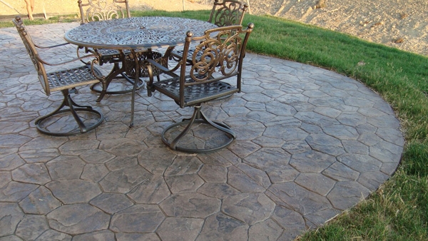 hình ảnh một góc sân vườn với bộ bàn ghế kim loại bắt mắt, sàn lát gạch bê tông giả đá