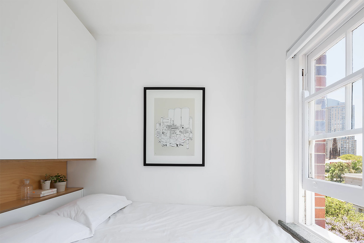 hình ảnh toàn cảnh phòng ngủ căn hộ 27m2 với tủ âm tường đầu giường, hốc gỗ, tranh treo tường, cửa sổ kính