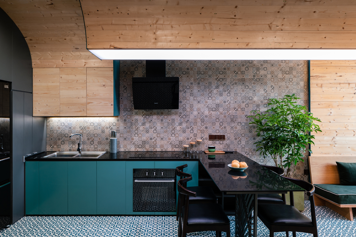 hình ảnh phòng bếp ăn tiện nghi với tủ bếp sơn màu xanh dương, trần vòm ốp gỗ, bàn ăn màu đen ngay cạnh