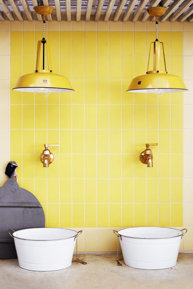 hình ảnh phòng tắm với gạch ốp tường màu vàng chanh, bộ đôi đèn thả, hai chậu rửa lạ mắt