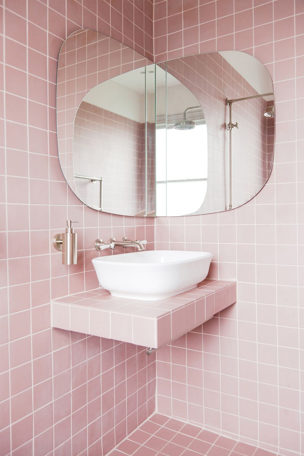 hình ảnh một góc phòng tắm với gạch ốp lát màu hồng, gương góc tùy chỉnh