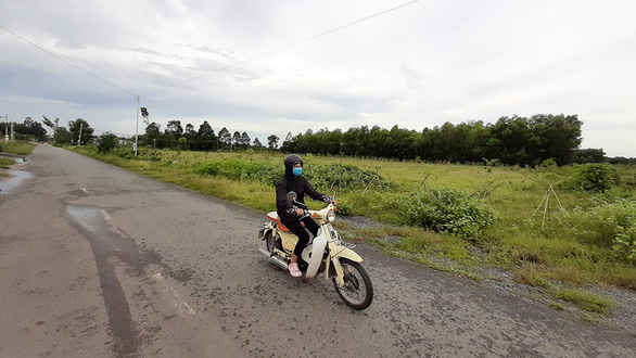hình ảnh đất nền nằm giáp đường có một một người đang đi xe máy