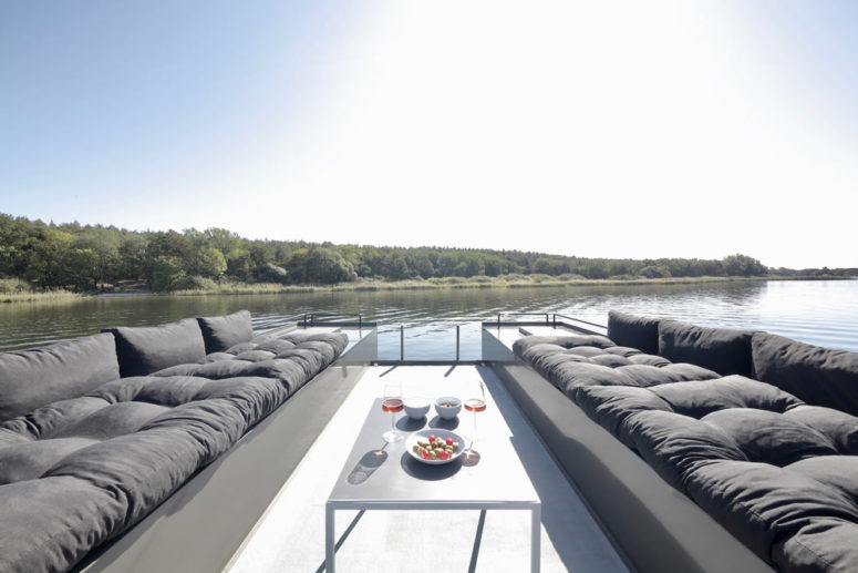 hình ảnh không gian thư giãn trên sân thượng nhà thuyền với 2 ghế sofa dài màu xám đậm, bàn trà ở giữa