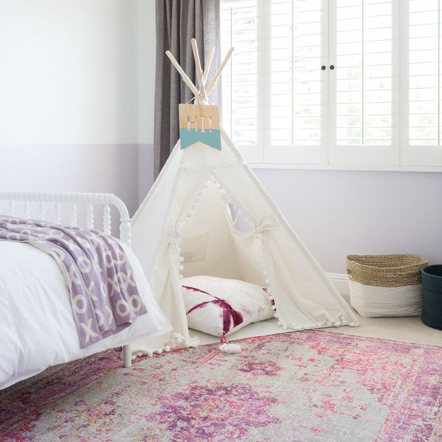 hình ảnh phòng ngủ cho bé với ga gối màu trắng, tím oải hương, lều chơi đặt cạnh cửa sổ kính