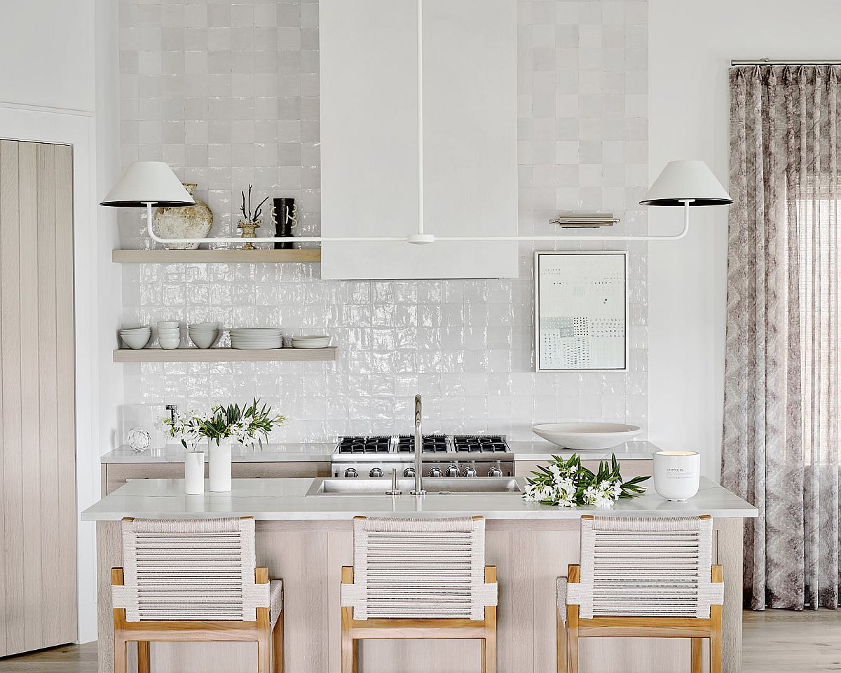hình ảnh phòng bếp màu trắng chủ đạo với gạch ốp tường, ghế gỗ, đèn gắn tường màu trắng