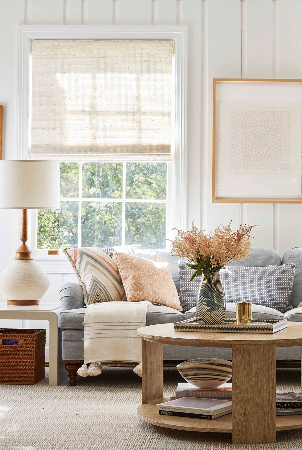 hình ảnh một góc phòng khách nhỏ với sofa ghi xám, gối tựa êm ái, khung cửa sổ kính lớn cho phép ánh sáng tự nhiên ngập tràn không gian phòng